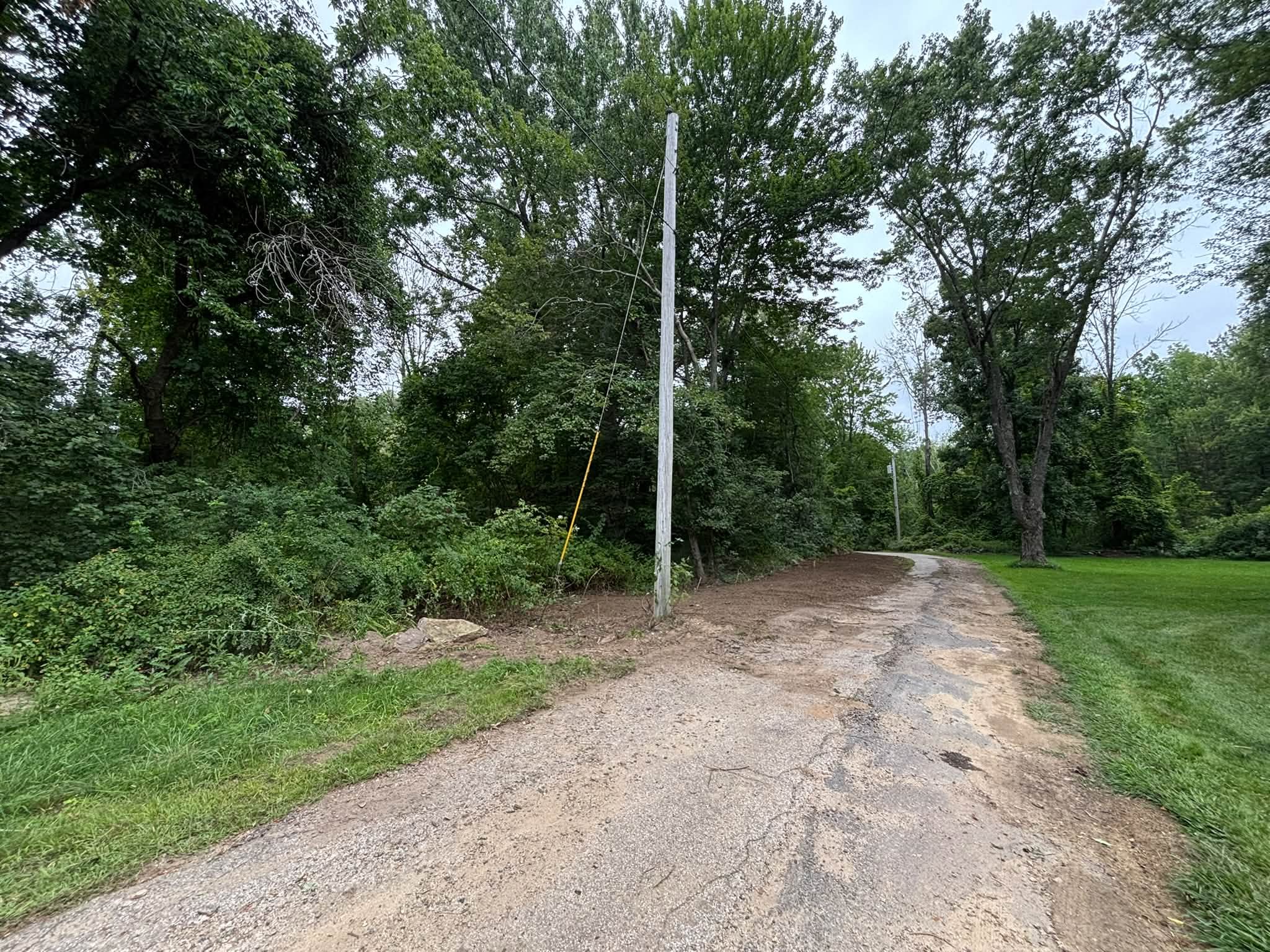 After — clean driveway edge with established grass buffer, Spencer MA